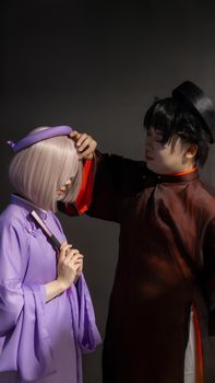 Two individuals in detailed cosplay costumes, capturing a moment of interaction.