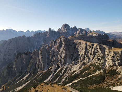 Breathtaking aerial view of the rugged Dolomites in Vêneto, Italy, showcasing dramatic peaks and clear skies.