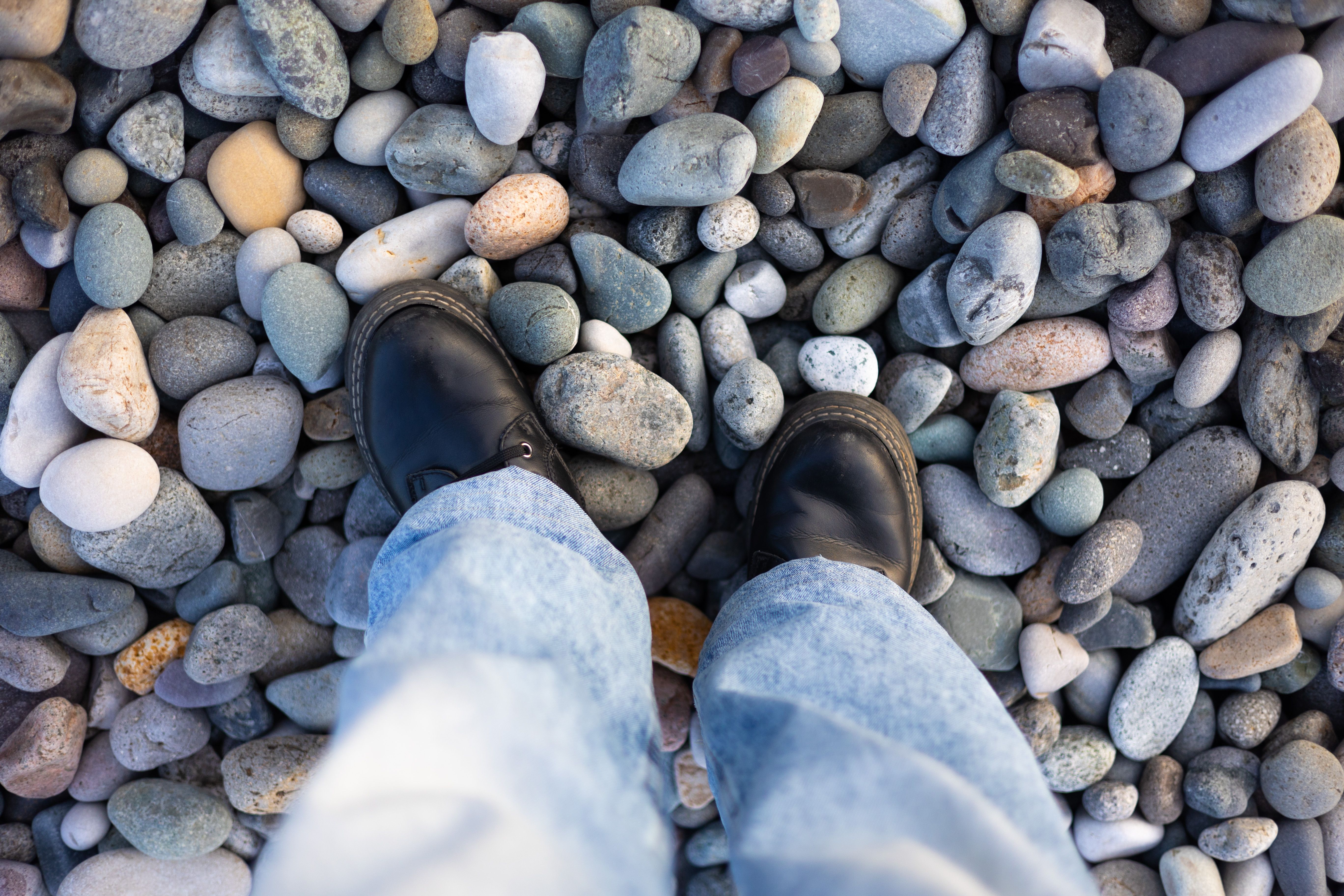 Water shoes on a pebble beach in Croatia, with clear Adriatic Sea in the background.