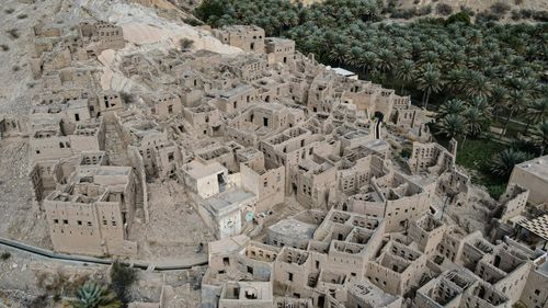 Free Explore aerial view of ancient abandoned village ruins surrounded by palm trees. Stock Photo