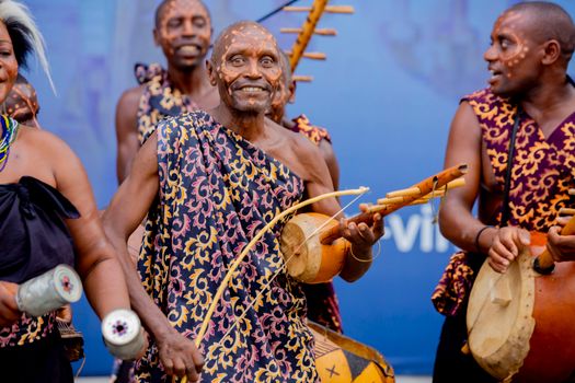 Joyful musicians performing African music with traditional instruments and attire.