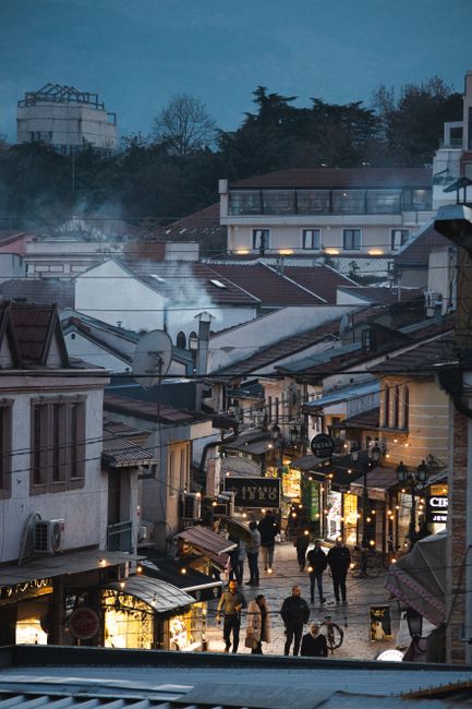 Charming twilight in Skopje's Old Town with people exploring the lively streets.