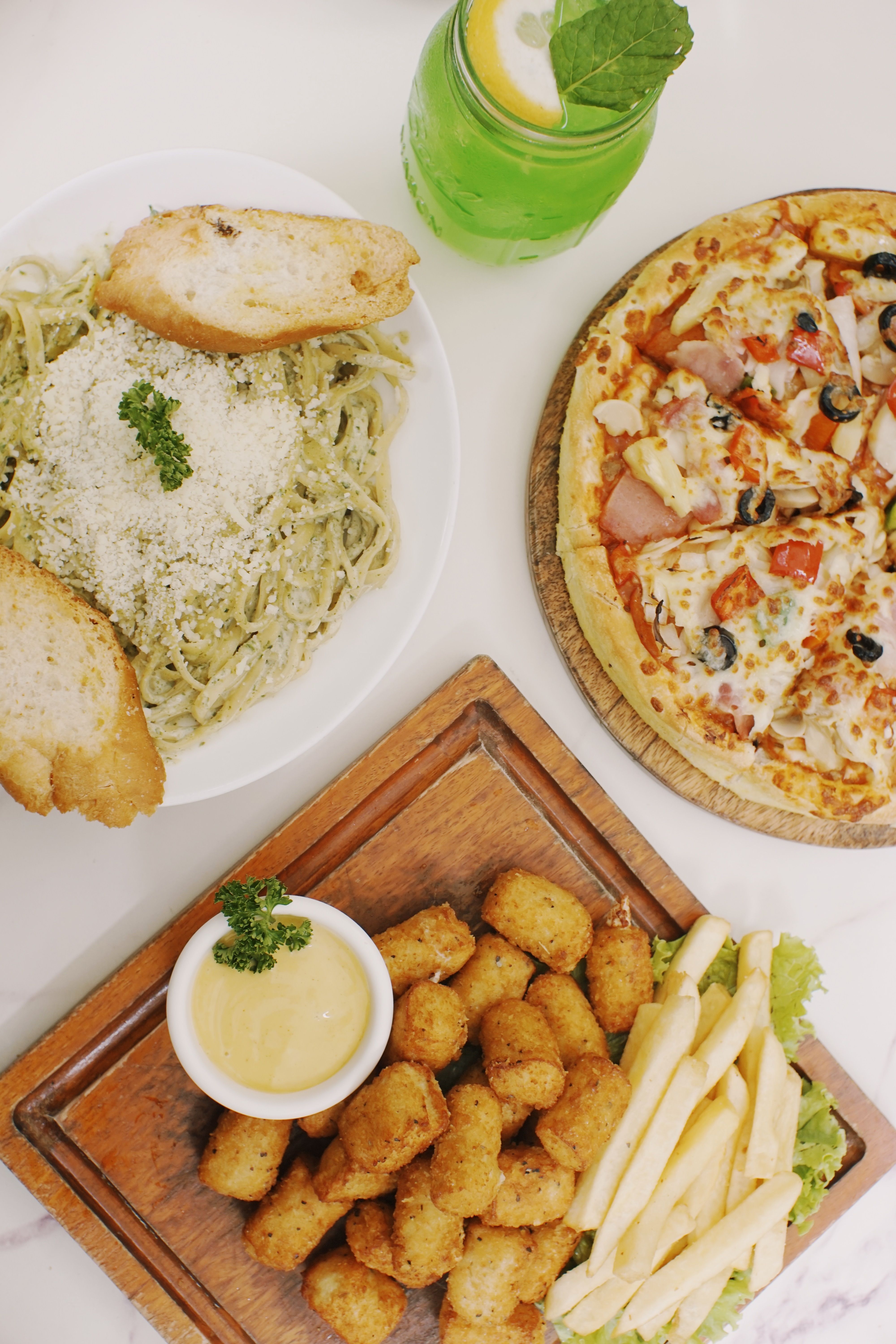 Top view of a delicious Italian meal featuring pizza, pasta and appetizers
