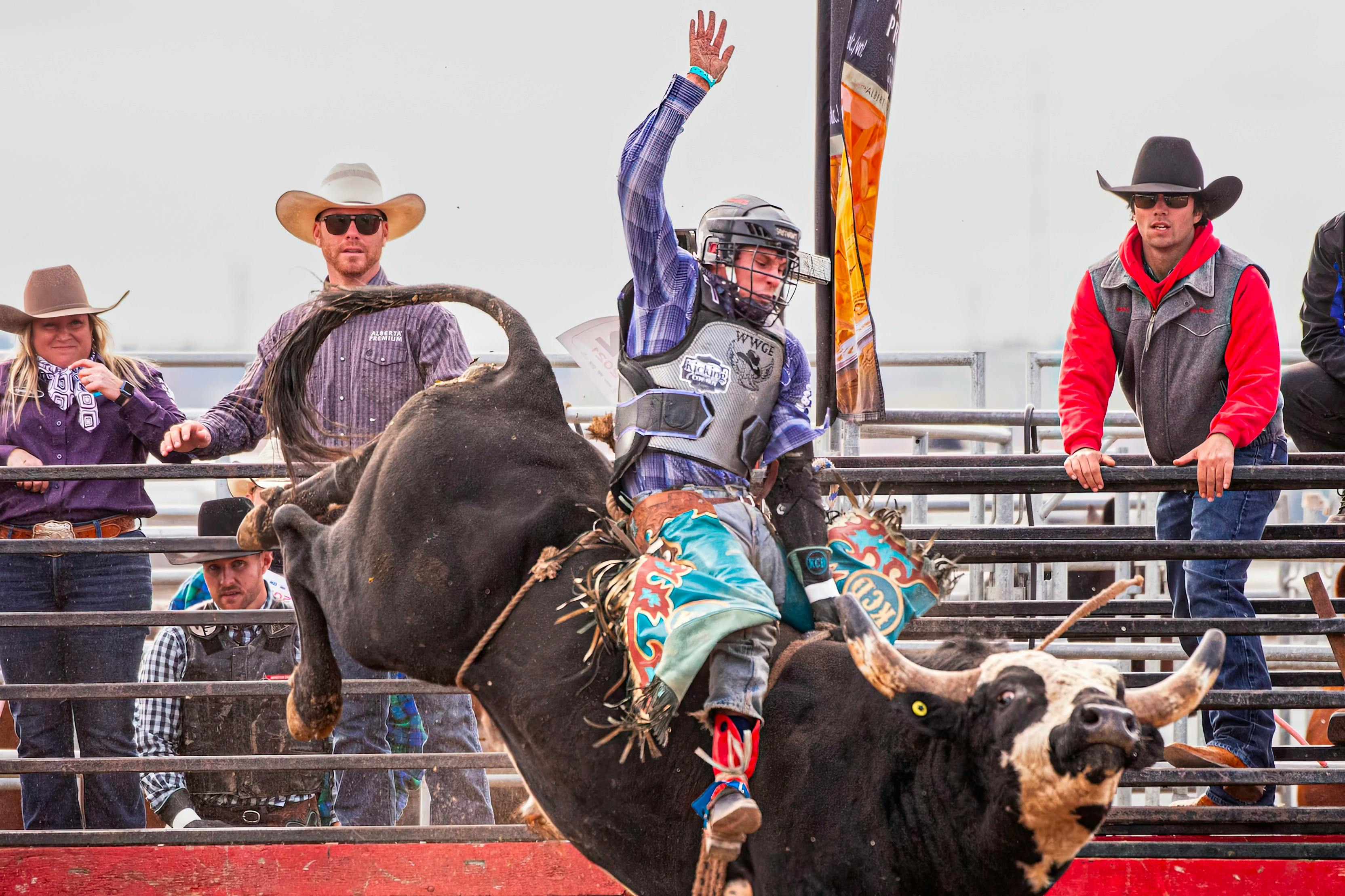 Dynamic scene of a bull rider in action during a rodeo event with spectators watching intently.