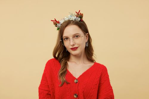 Free Portrait of a woman in a red sweater with glasses and festive headpiece. Stock Photo