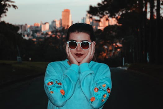 日落时分，一位戴着太阳镜的时尚女士在户外摆姿势，背景是充满活力的城市景观