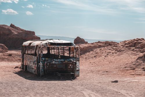 Free A weathered, abandoned bus in San Pedro de Atacama's desolate desert landscape. Stock Photo