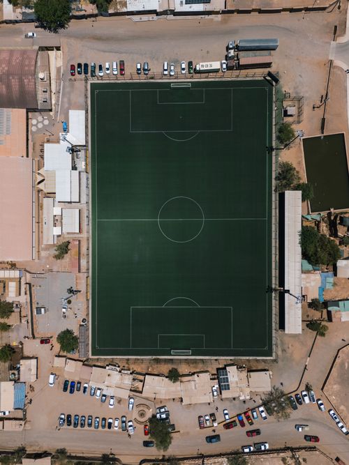 Free Aerial photograph of a soccer field surrounded by buildings and cars in San Pedro de Atacama, Chile. Stock Photo
