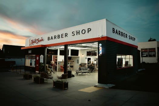 Barber shop during twilight with people inside, creating a warm and welcoming atmosphere.