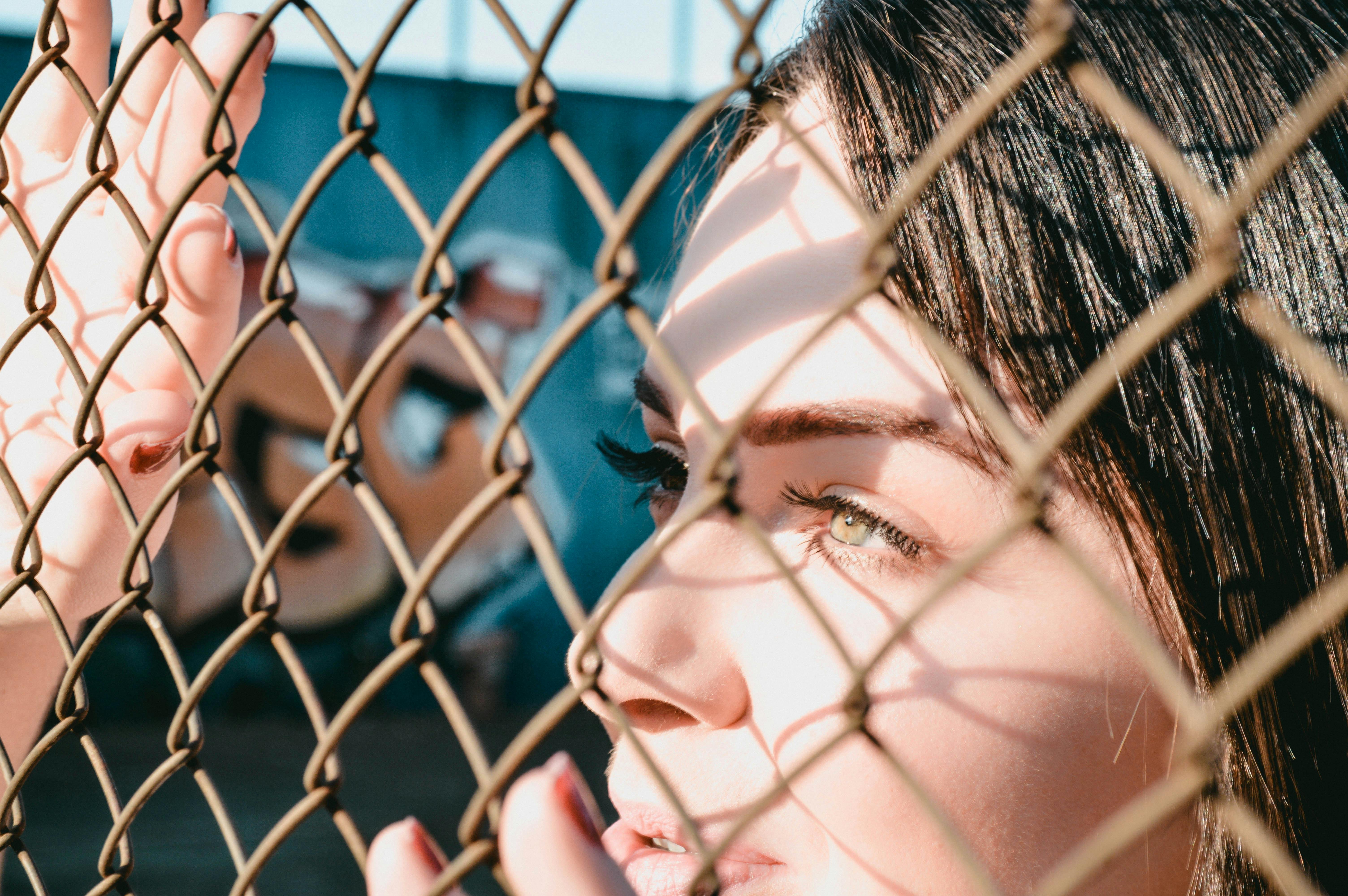woman leaning on chain link fence