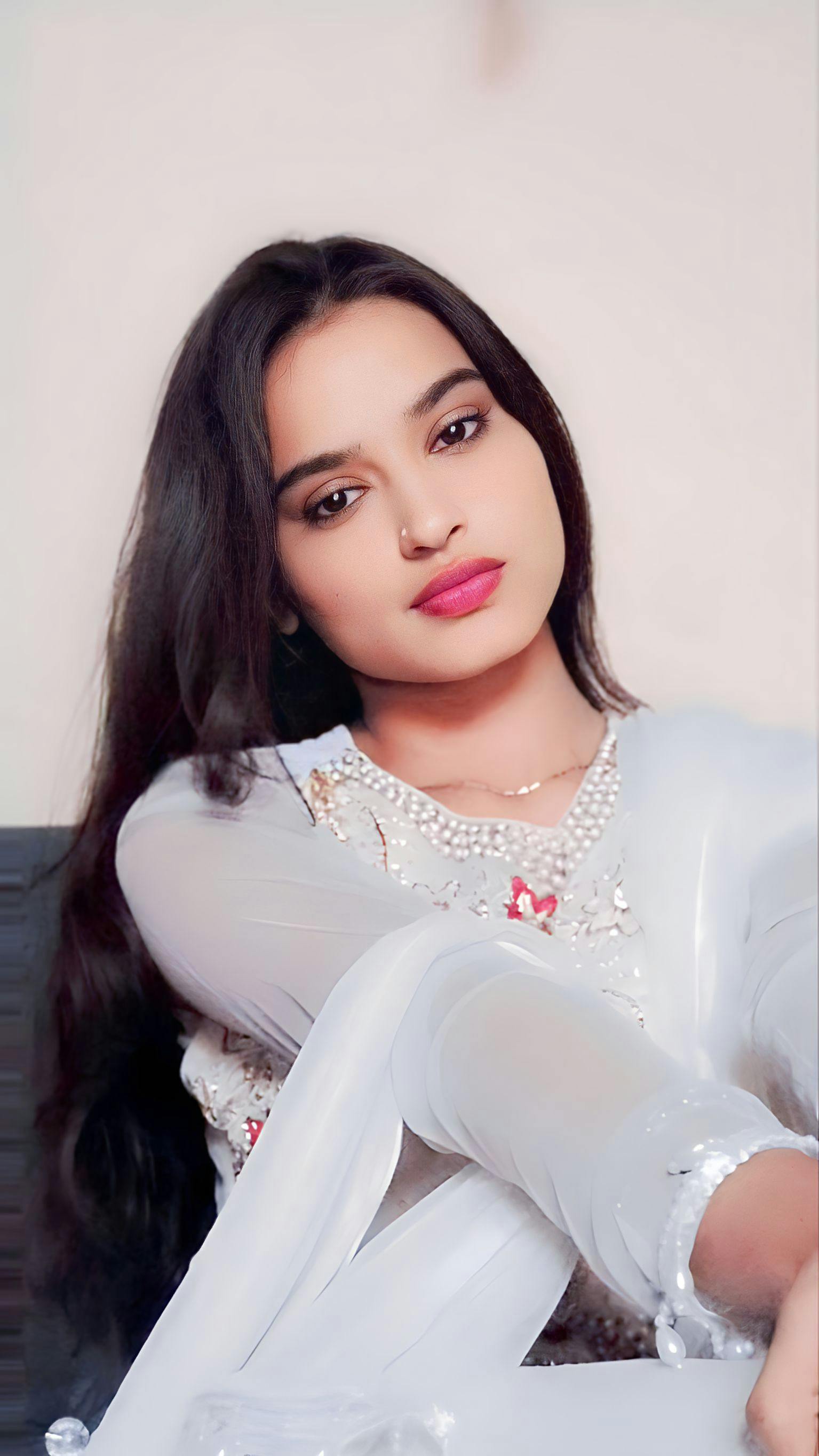 Beautiful woman posing gracefully in traditional white attire.