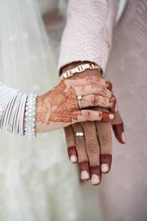 Free Close-up of a newlywed couple's hands adorned with mehndi and rings, symbolizing love and commitment. Stock Photo