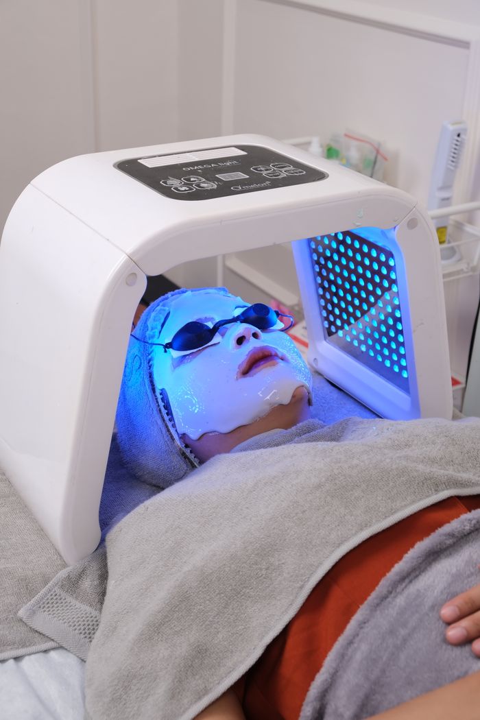 Woman relaxing during professional LED light therapy facial session