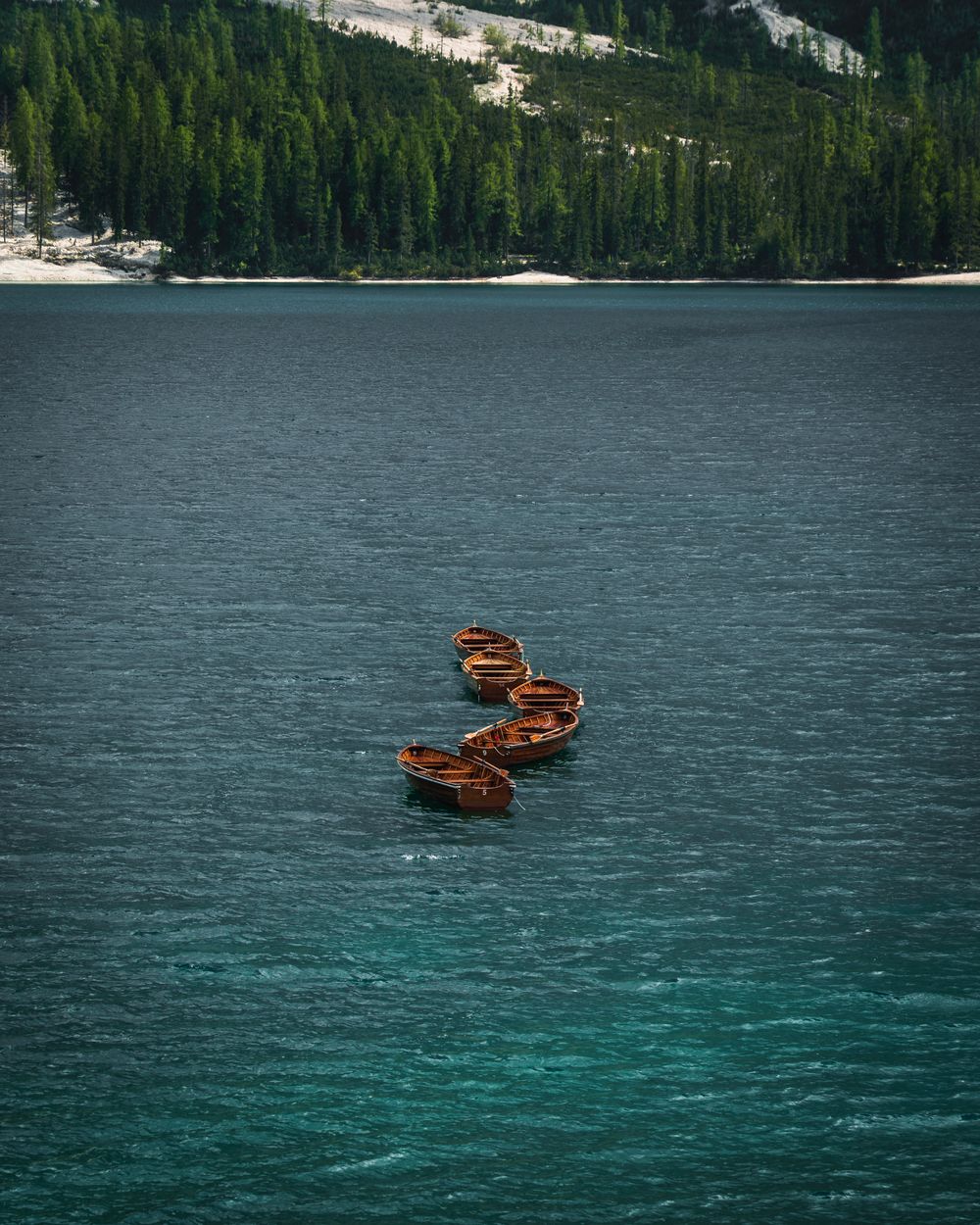 Bărci de lemn plutind pe apa verde a Lacului Braies