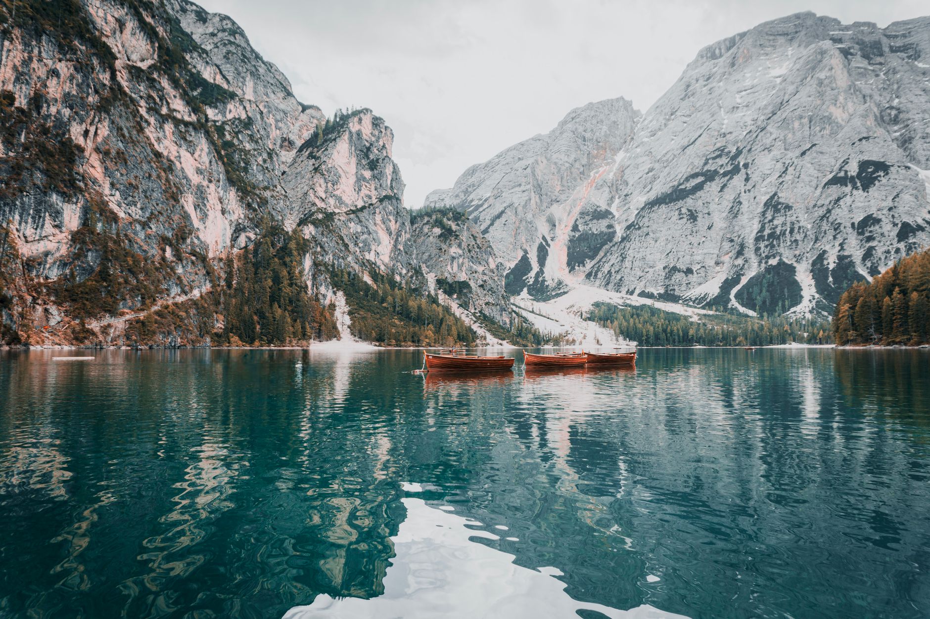 Rowboats on Lago di Braies below pale limestone peaks, an easy lake stop for the Dolomites without hiking