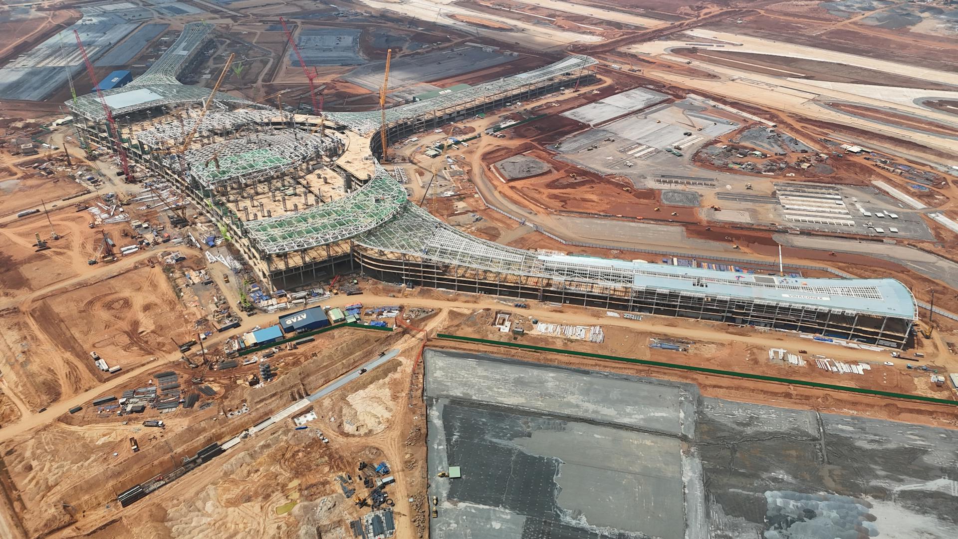 Expansive aerial shot of a construction site with cranes and building foundations in Đồng Nai, Việt Nam.