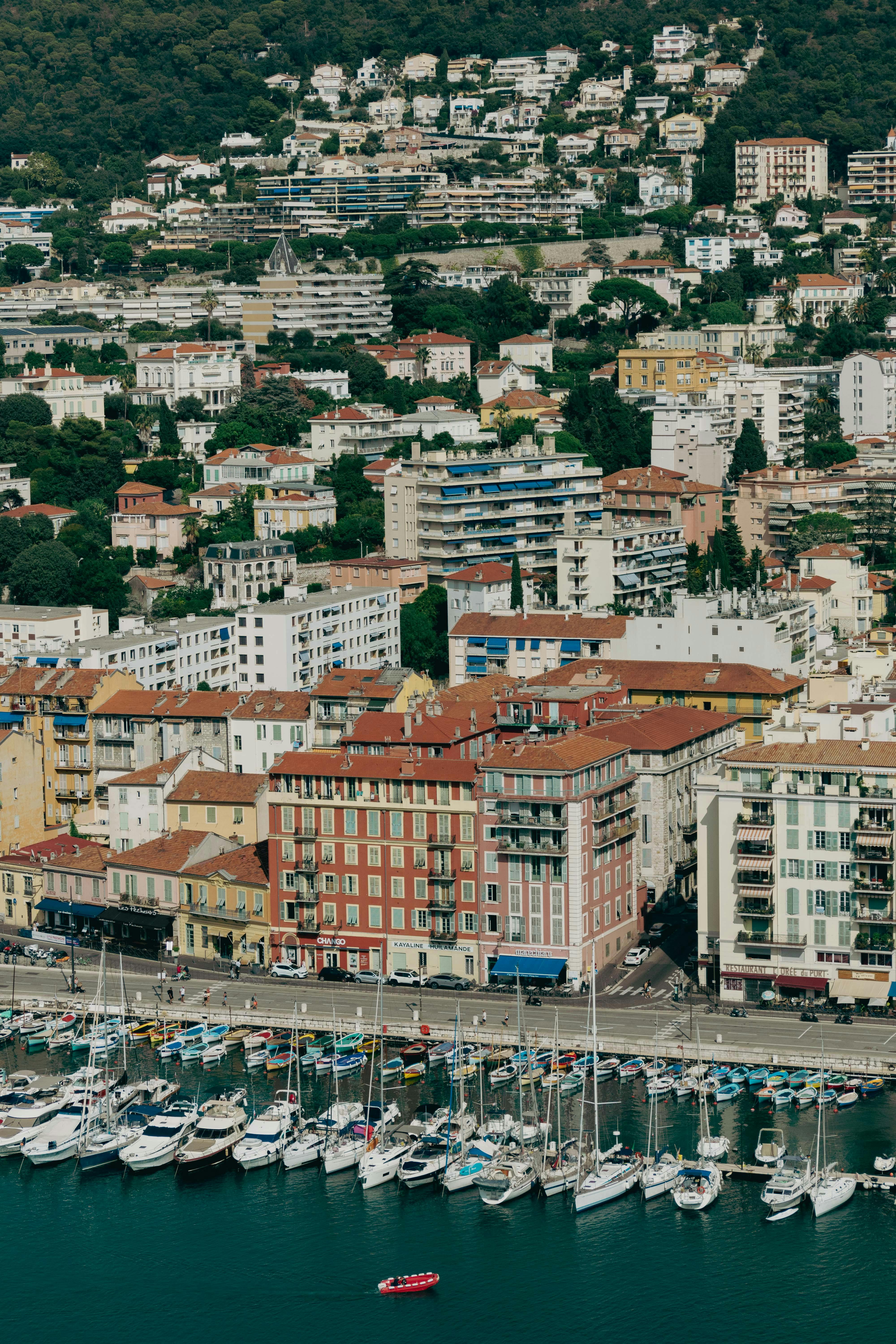 Stunning aerial view of Nice Harbor in France, showcasing yachts and colorful buildings.