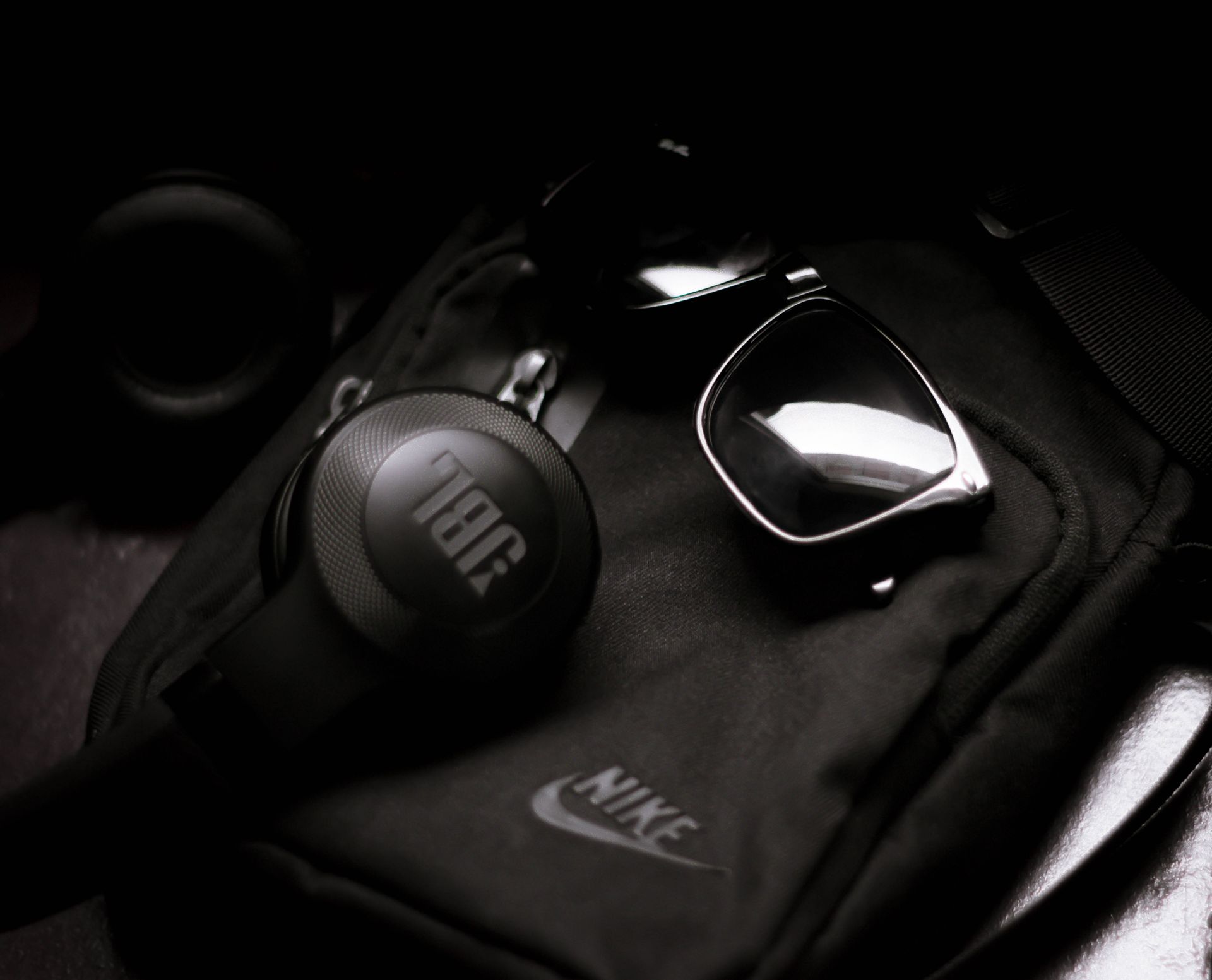 A sleek flat lay of black accessories including sunglasses and headphones for a modern lifestyle.