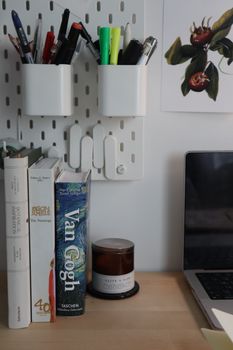 A clean and organized desk setup with books, stationery, and a laptop in an Istanbul home office.