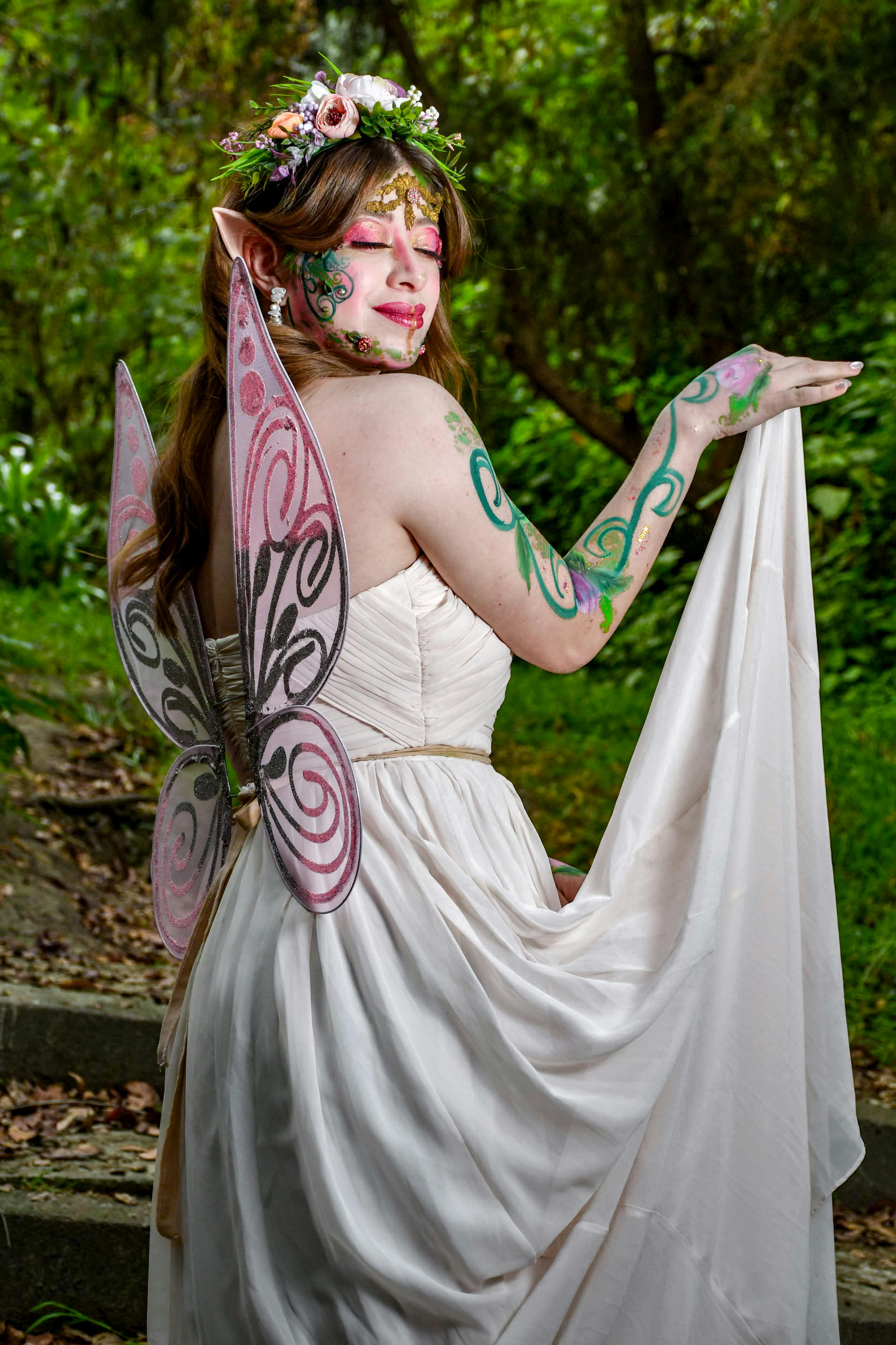 Fantasy-themed portrait of a woman in fairy costume outdoors.