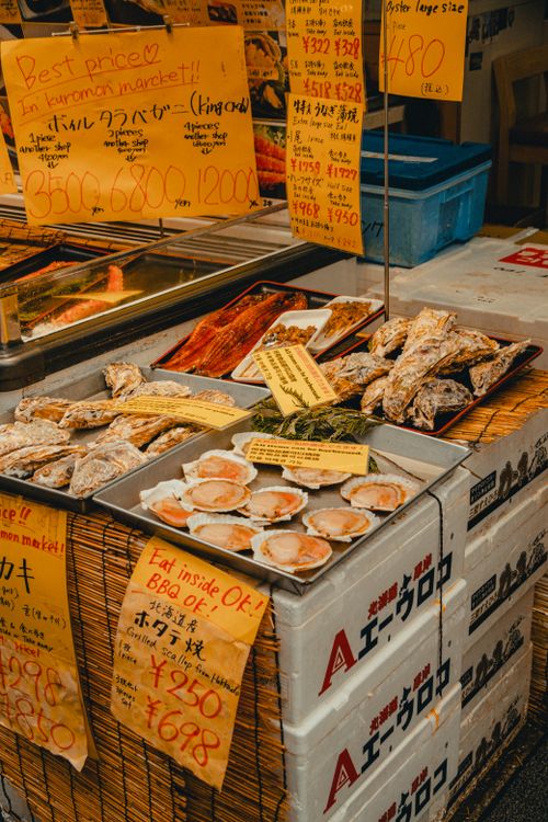 Free Colorful display of seafood and pricing signs at a bustling market stall. Stock Photo