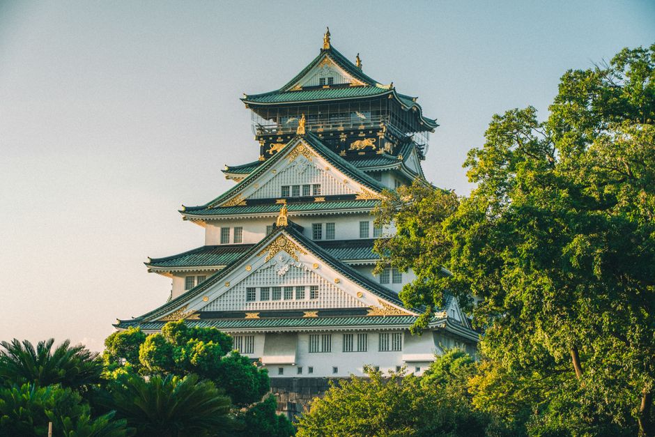 Stunning view of Osaka Castle surrounded by vibrant summer greenery.