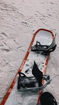 Close-up of a snowboard with bindings on fresh snow, capturing the essence of winter sports.