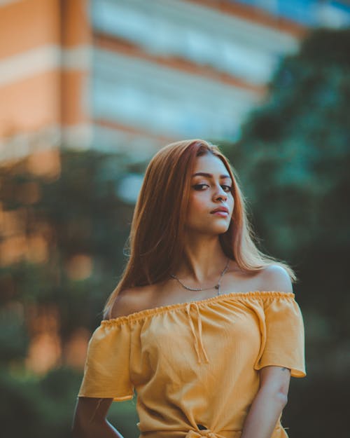 Selective Focus Photo of Woman in Yellow Off-shoulder Top Posing
