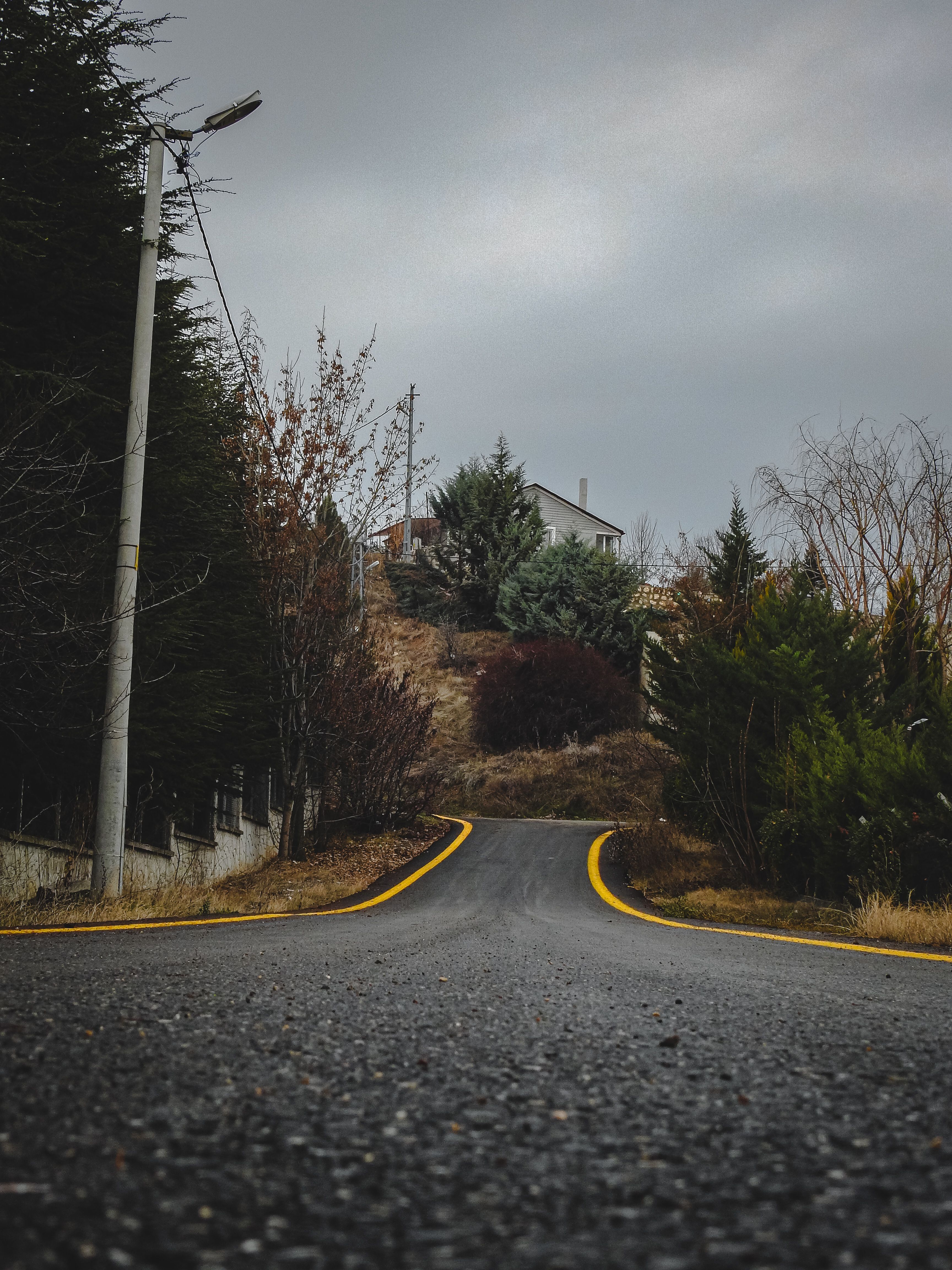 Scenic Rural Road Leading to Hilltop House · Free Stock Photo