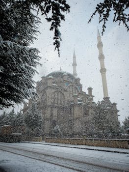 Majestic mosque surrounded by heavy snowfall and snowy trees in winter.