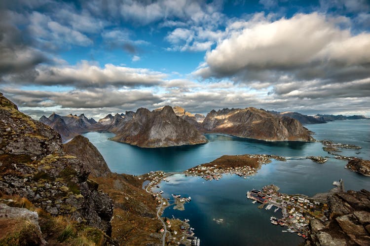 Landscape Photography Of Mountains Surrounded By Water