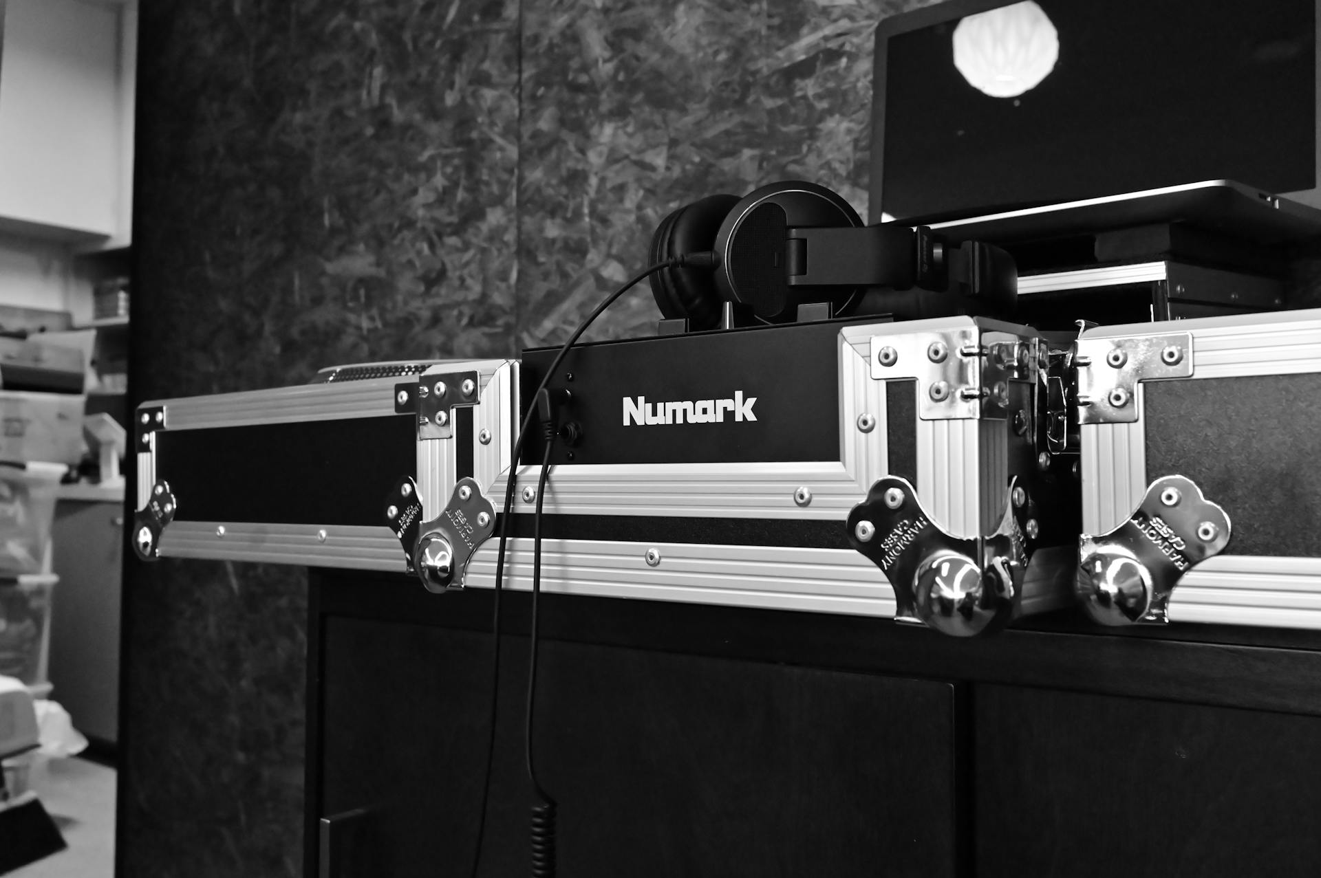 Black and white photo of professional DJ equipment with Numark branding and headphones.