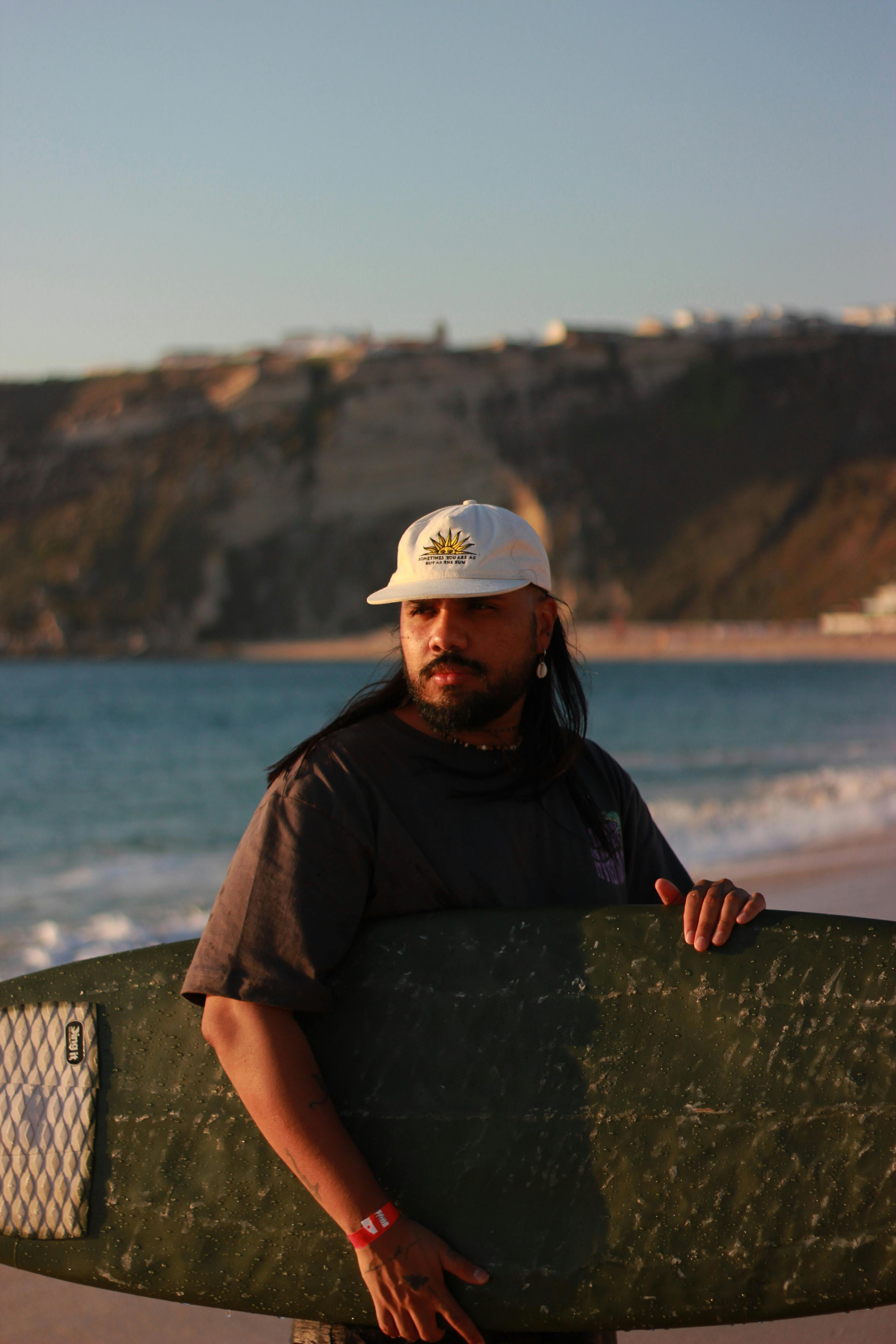 surfer holding board at nazare beach