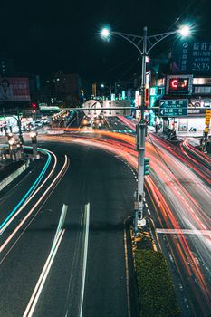 Aerial view of vibrant light trails on a busy city street at night, showcasing urban energy.