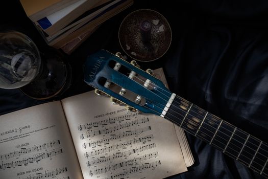 A relaxing setup with guitar, sheet music, and books offering a cozy, musical ambiance.