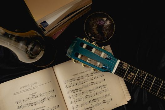 A nostalgic composition featuring a guitar, sheet music, and lamp in a cozy indoor setting.