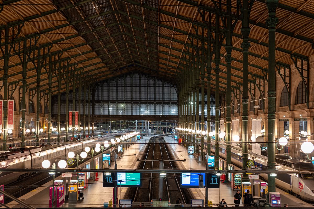 A Paris station at night with trains at the platform