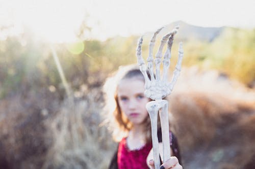 Girl Holding White Hand Skeleton Selective Focus Photography