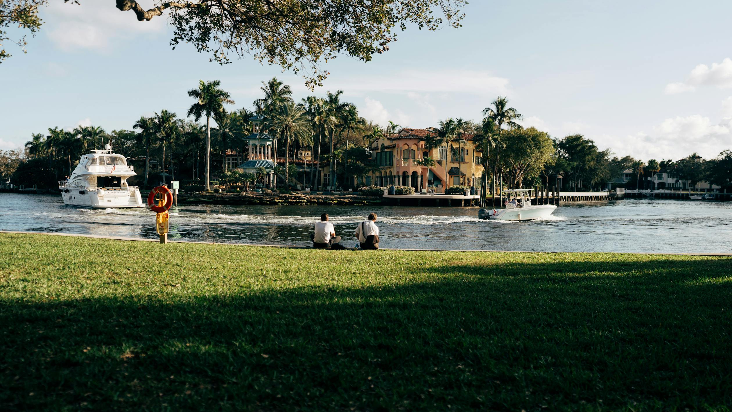 Serene Riverside Scene with Boats and Palm Trees