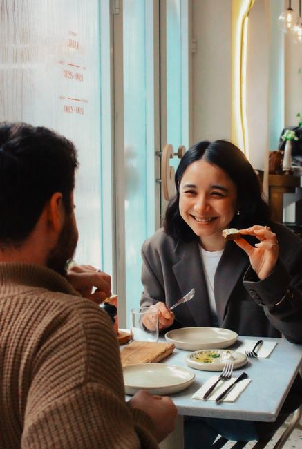 Happy couple enjoying a meal together in a cozy cafe setting.