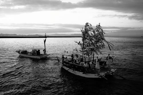 Photographie En Niveaux De Gris De Personnes Sur Des Bateaux