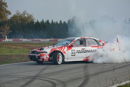 Free A race car performing an impressive drift on a track, surrounded by smoke. Stock Photo