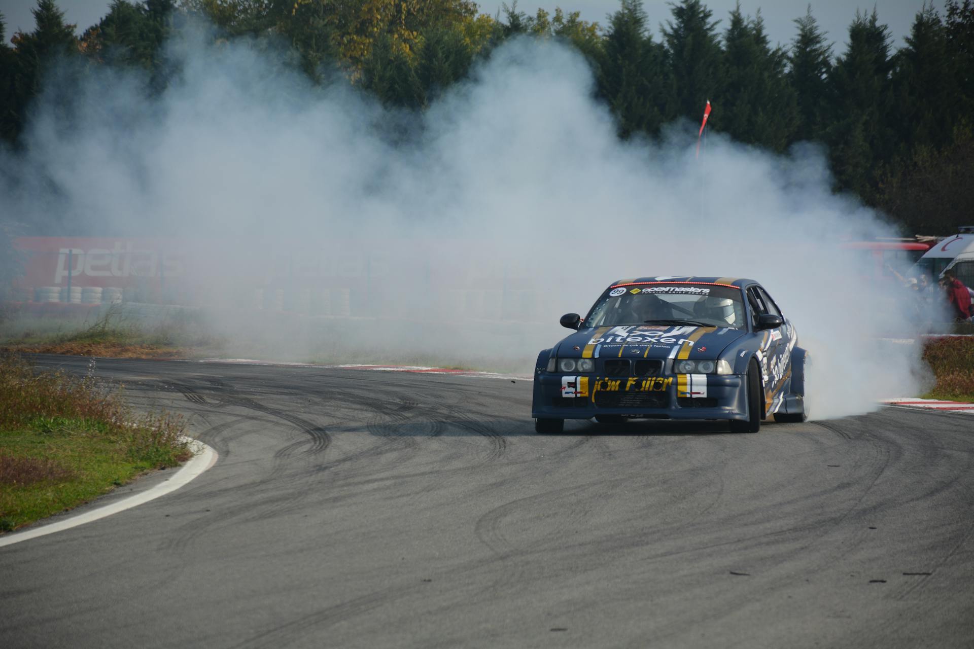 Dynamic shot of a car drifting on a racetrack in Kocaeli, Türkiye with smoke trails and speed.