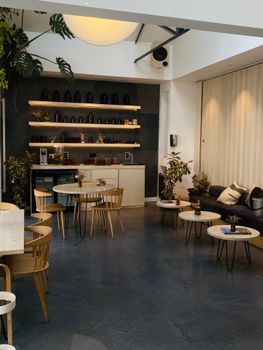 Charming café interior with modern minimalist design featuring wooden furniture and soft lighting.