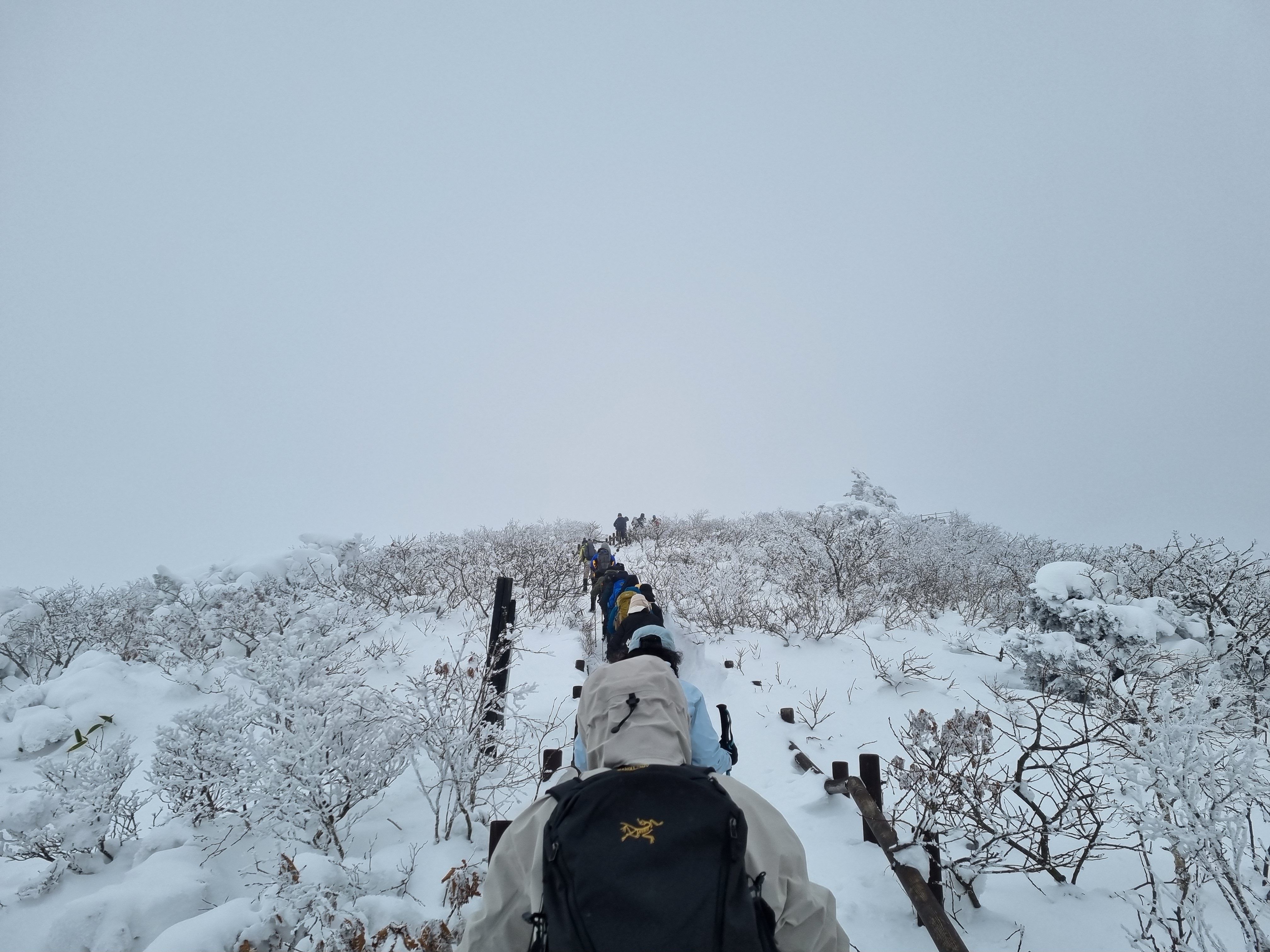 Adventurers trek through a snowy mountain path, capturing the essence of a winter expedition.
