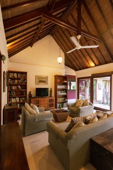 Inviting living room in Bali with wooden beams, bookshelves, and cozy sofas.. pexels, inviting, living