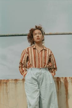 一位时尚女性身着复古条纹服装，自信地在户外摆姿势