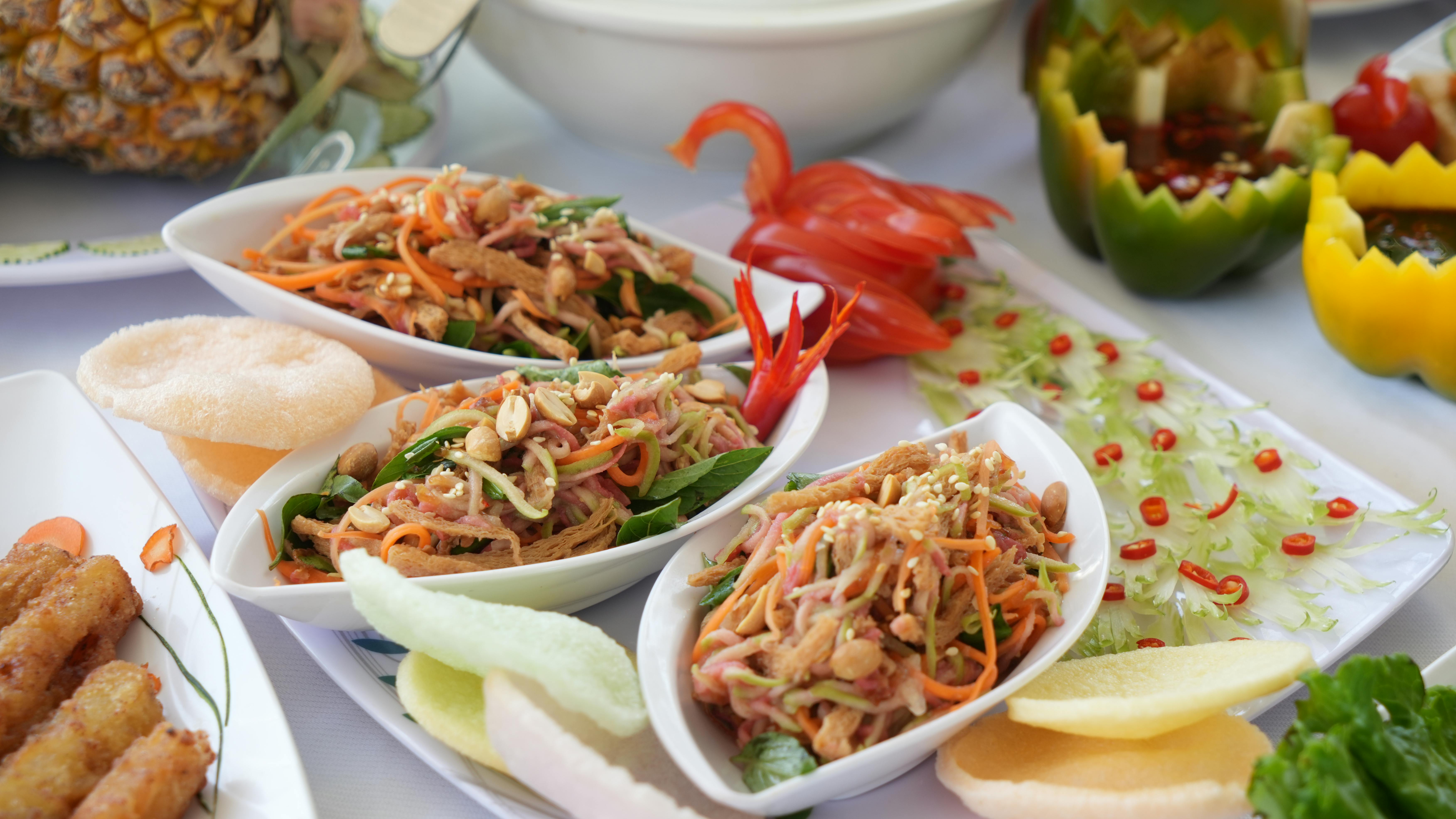 Vibrant Asian dishes with fresh ingredients and garnishes on a table setting.