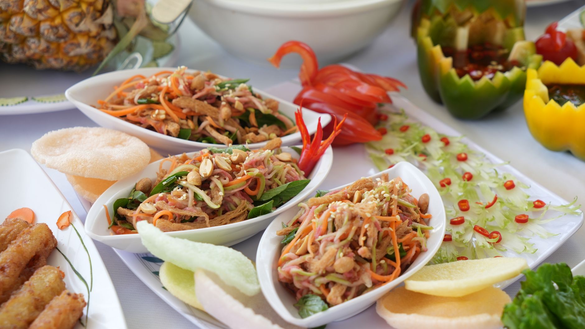 Vibrant Asian dishes with fresh ingredients and garnishes on a table setting.