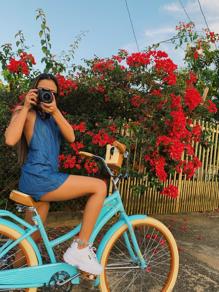 Woman Seated On Bike Using Camera